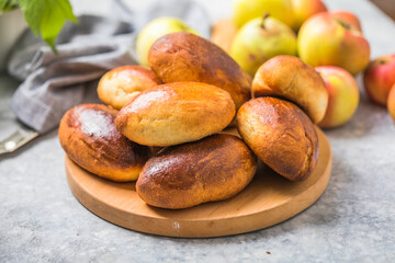 Ready-made baked pies (pirogi) with apple. Traditional russian cuisine.