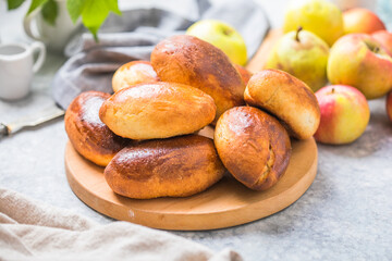 Ready-made baked pies (pirogi) with apple. Traditional russian cuisine.