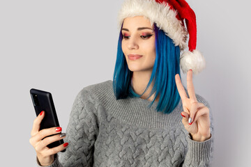 Beautiful happy young woman in santa hat take selfie