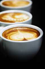 Cup of coffee. Latte art made by barista focus in milk and coffee. Vintage color