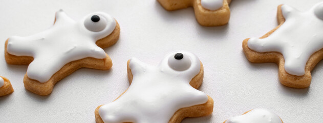 Close up of decorating cute Halloween cookies with frosting in icing bag.