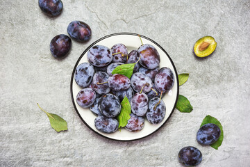 Ripe blue plums on a plate