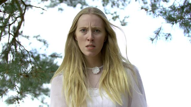 Beautiful Blonde Young Adult Girl With Long Hair Wearing White Dress Being Angry