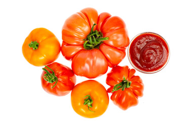 Fresh tomatoes and ketchup in glass form.