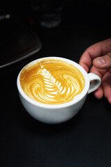 Cup of coffee. Latte art made by barista focus in milk and coffee. Vintage color