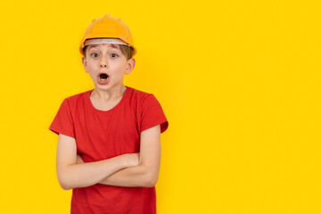 Surprised guy in hardhat on yellow background. Choice of future profession. Copy space,