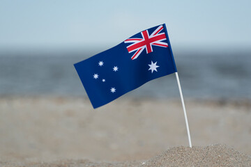 Australian flag in sand on the beach. Seaside holiday in Australia.
