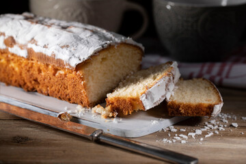 
Fresh sliced ​​muffin with powdered sugar on wooden table