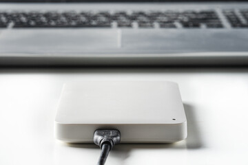 White external portable USB hard drive. Copying data to external HDD storage. Data backup concept