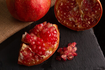pomegranate fruit, placed on a black slate
