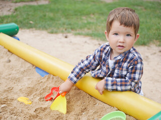Lonely caucasian child playing with sand.