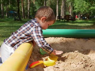 Lonely caucasian child playing with sand.