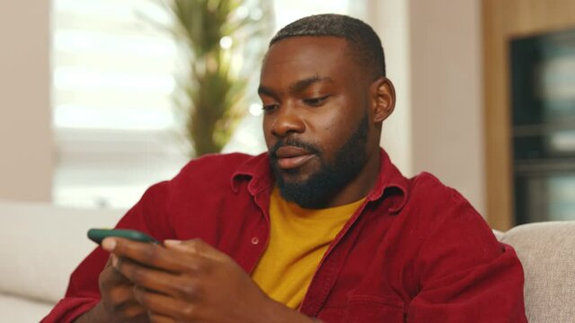 Portrait face african american young man recording voice message use phone in social network. Talking smiling using wifi indoors communicate technology microphone speaker. Slow motion
