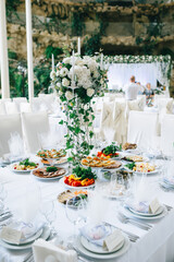 Wedding table setting decorated with fresh flowers and a vintage vintage candlestick with candles.