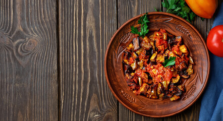 Grilled Turkish eggplants in tomato sauce (soslu patlican or şakşuka.). A tasty and simple Turkish dish or appetizer for main courses. Layout on dark wooden table with copy space
