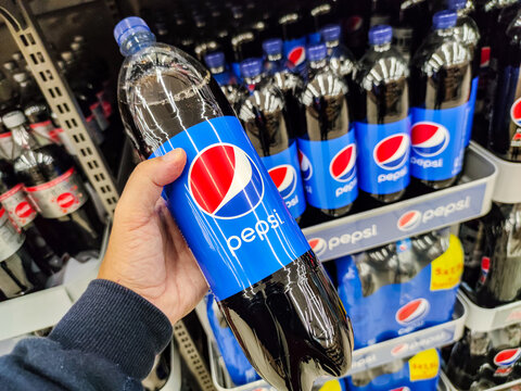 Closeup of Man hand buying Pepsi Max soft drink on French supermarket