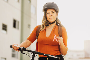 Healthcare and medicine concept - woman holding pink breast cancer awareness ribbon outdoors