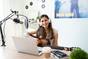 Pretty girl playing guitar in a radio station