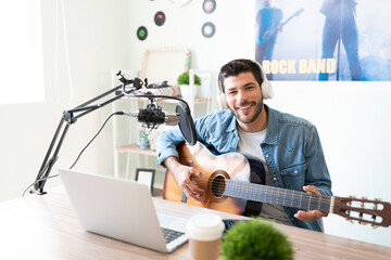 Male artist playing the guitar in a studio