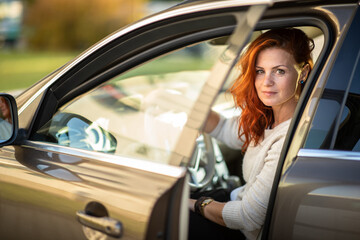 Fototapeta na wymiar Pretty, young woman driving a car - Invitation to travel. Car rental or vacation.