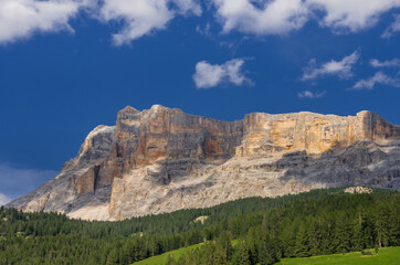 Fototapeta na wymiar Late afternoon deep color view of Sasso di Santa Croce mountain range west wall and Mount Cavallo from La Villa village in Val Badia (valley), Eastern Dolomites, Alta Badia, South Tirol, Italy.