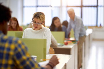 Female student carefully studies the lesson at a lecture