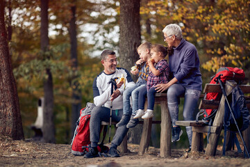 Grandmother, grandfather and grandchildren enjoying the fruits in the forest