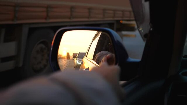 Family trip. The family is driving on the highway. Reflection in the mirror. Sunset time