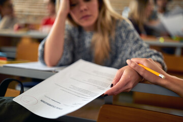 Sad female student disenchanted about low grade at the exam. Smart young people study at the college. Education, college, university, learning and people concept