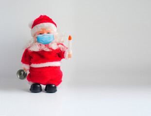 Toy Santa Claus in a medical face mask. Christmas background with a copy space
