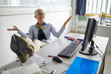 Female professor relaxed in the chair at her working place - obrazy, fototapety, plakaty