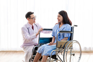 Doctor talking to woman in wheelchair after surgery. Doctor consulting, encourage patient about treatment before discharging from hospital. Medicine, Age, Health Care and People concept, Covid19.