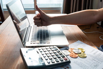 Close up of businessman or accountant hand on calculator to calculate and laptop, working on financial data report. Businessman working with calculator, business document and laptop computer notebook.