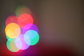 Die bunten und verschwommenen Lichter eines kleinen und wei&szlig;en Weihnachtsbaumes stehend auf einem roten Tuch.