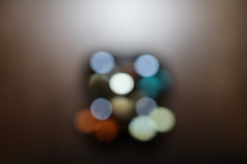 Die bunten und verschwommenen Lichter eines kleinen und wei&szlig;en Weihnachtsbaumes stehend auf einem roten Tuch.