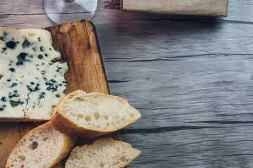 Queso Roquefort con trozos de pan sobre tabla de picar