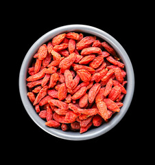Goji berries in a bowl on black background