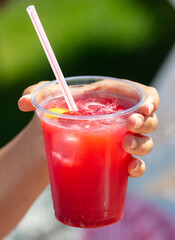 The girl is drinking a strawberry cocktail