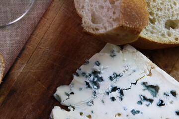 Queso Roquefort con trozos de pan sobre tabla de picar