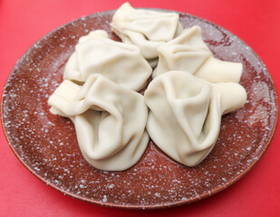 Boiled khinkali on a red table