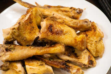 Grilled chicken placed on a white plate, ready to eat