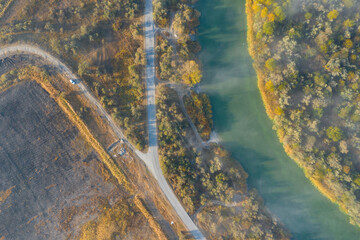 Fantastic foggy river and road. Dramatic unusual scene. Autumn landscape. Aerial view.