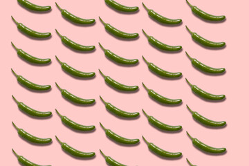 Green serrano chili peppers pattern on pink background.