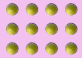 Group of green lemons on violet background.