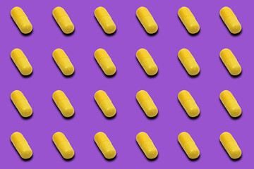 Group of yellow medicinal pills on purple background.