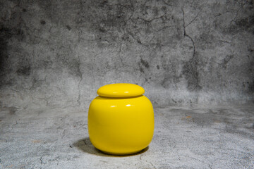 The yellow decorative plastic jar with cover on white