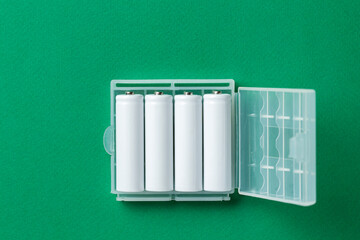White AA batteries on a green background. The most popular size of accumulators.