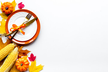 Thanksgiving place setting with cutlery and autumn leaves, top view