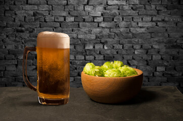 Beer brewing ingredients Hop in bag and wheat ears on wooden cracked old table. Beer brewery concept. Hop cones and wheat closeup. Sack of hops and sheaf of wheat on vintage background.