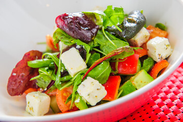Happy and colorful salad with greens, vegetables, feta cheese